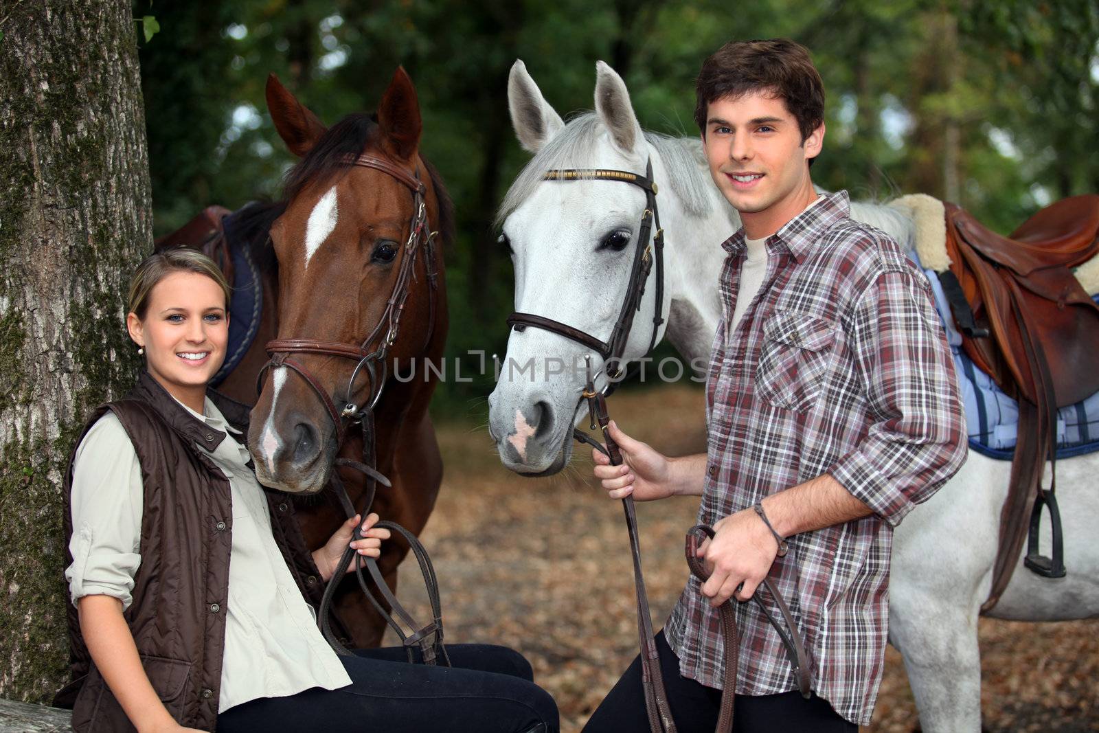 young couple and horses in forest