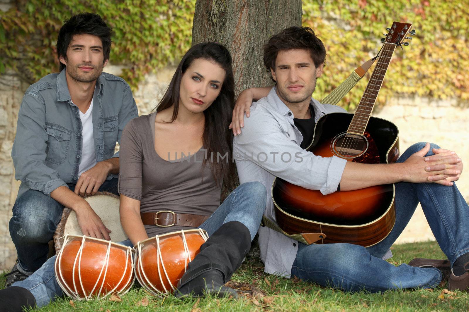 three musicians at the foot of a tree by phovoir