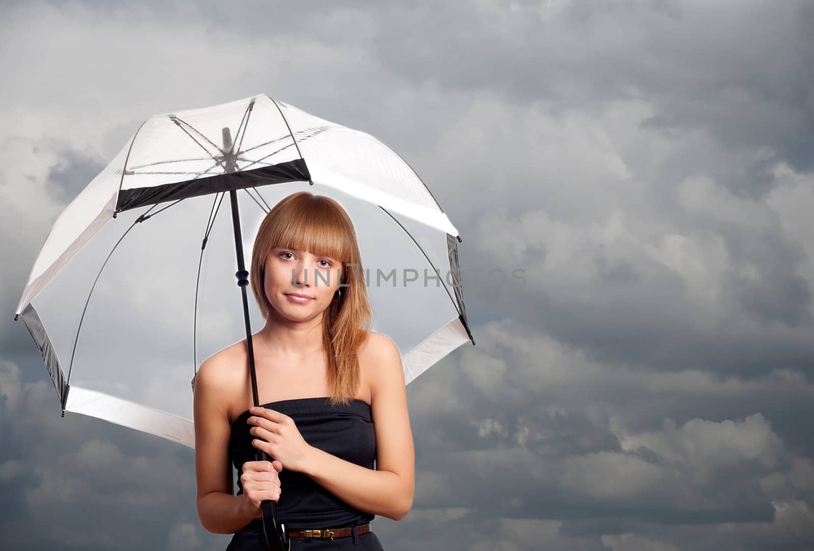 Young fashionable woman holding umbrella, dark sky background