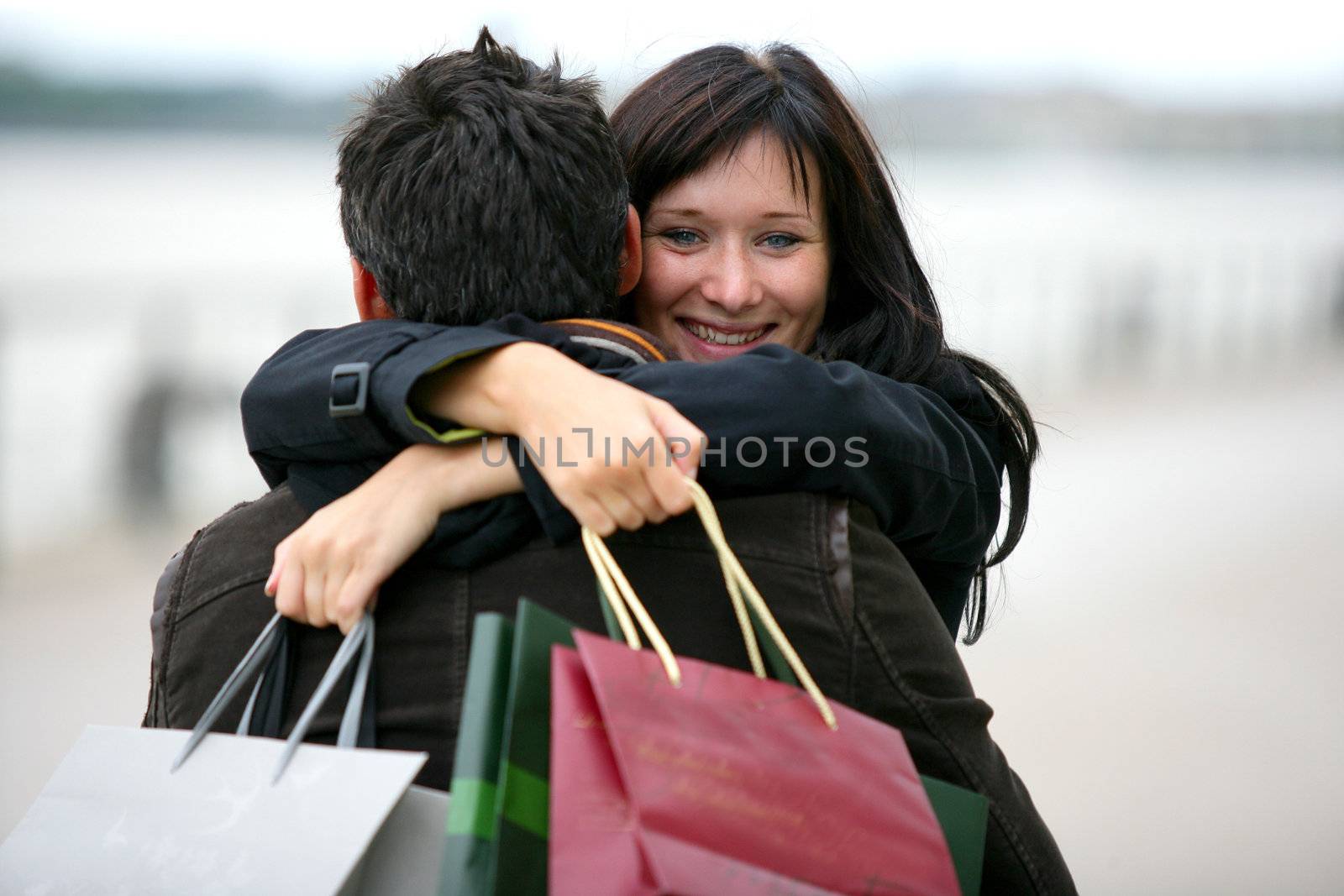 Woman thanking man for presents with hug