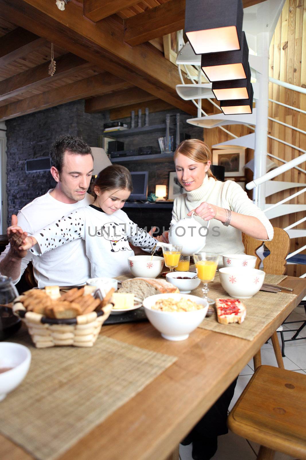 married couple and daughter having breakfast together by phovoir