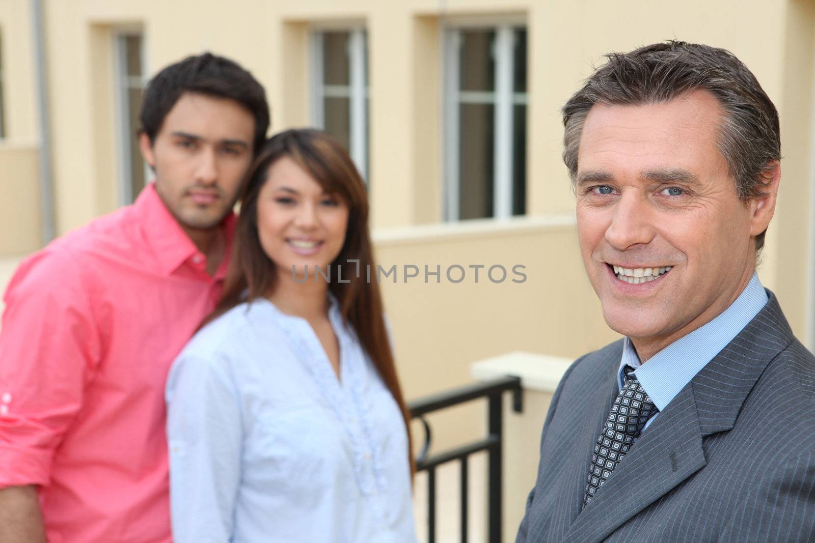 Estate agent with young couple by phovoir