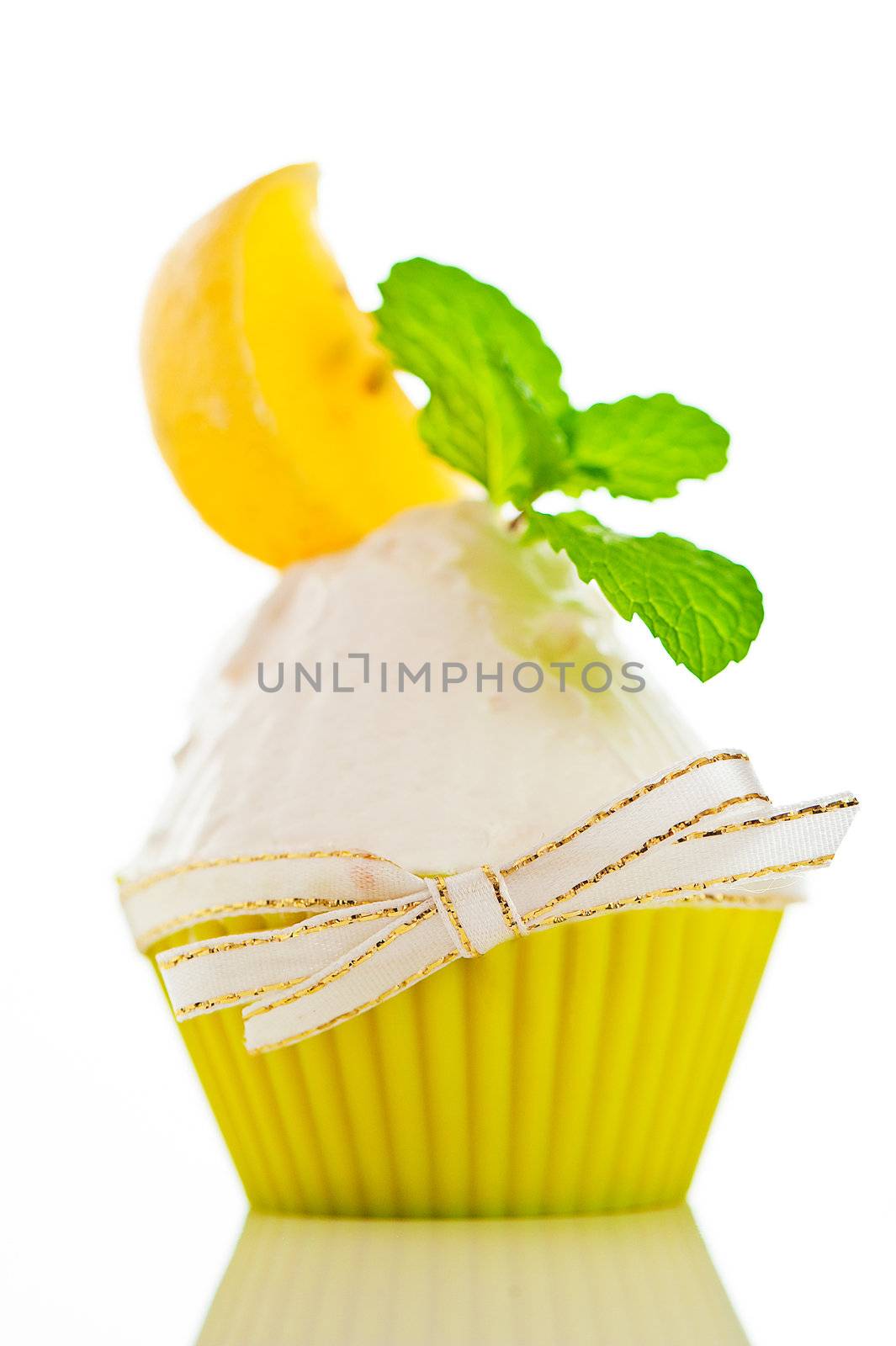 A refreshing lemon cupcake with a leaf of mint on white background