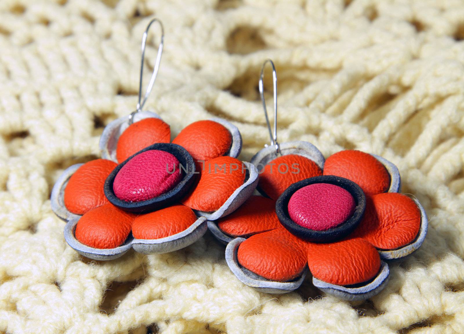 leather earrings in ethnic style on the knitted scarf