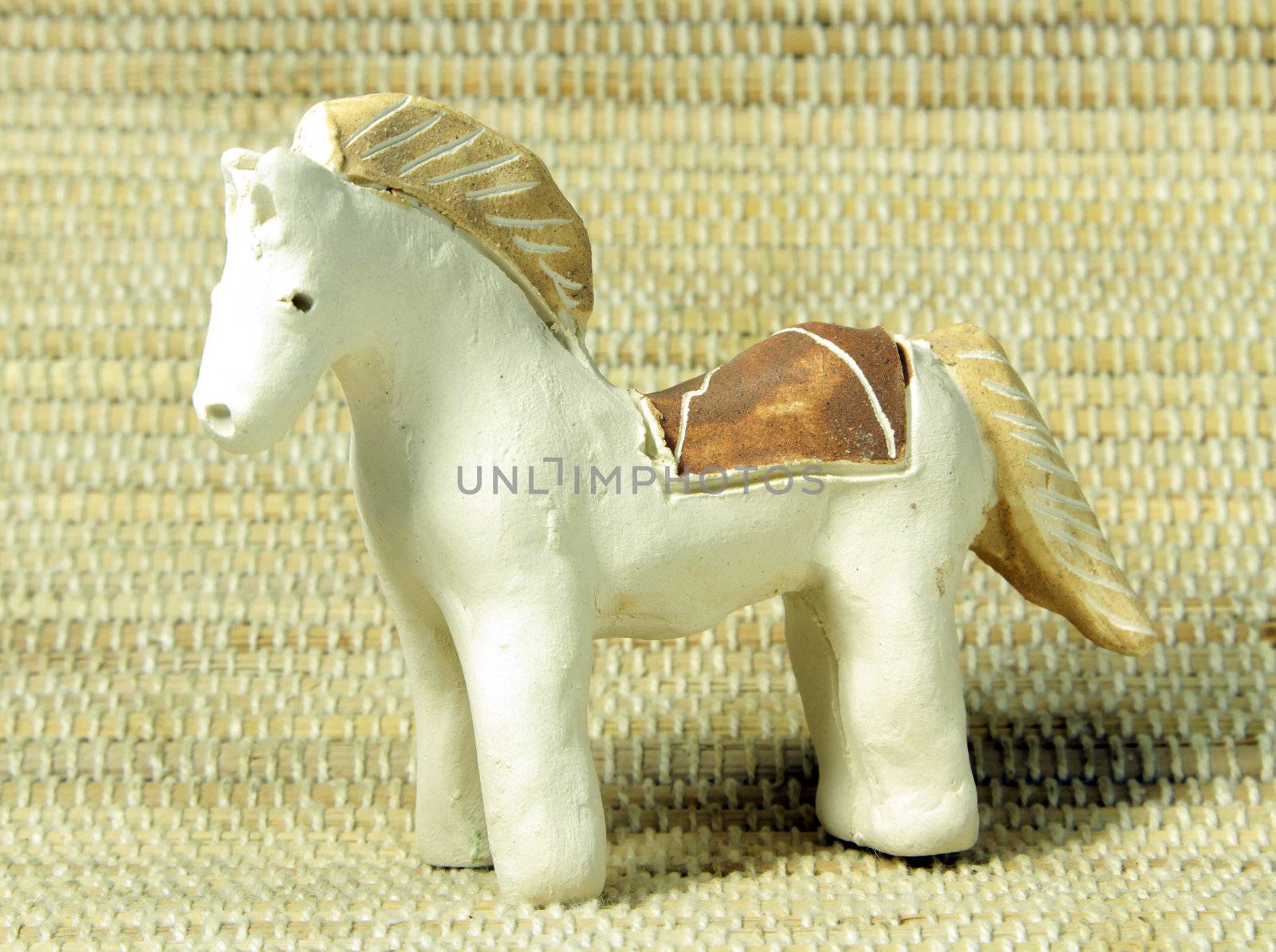 hand made clay ethnic horse on bamboo background