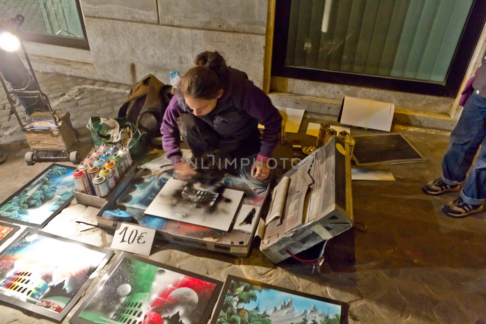 A street artrist making artwork using spray paint