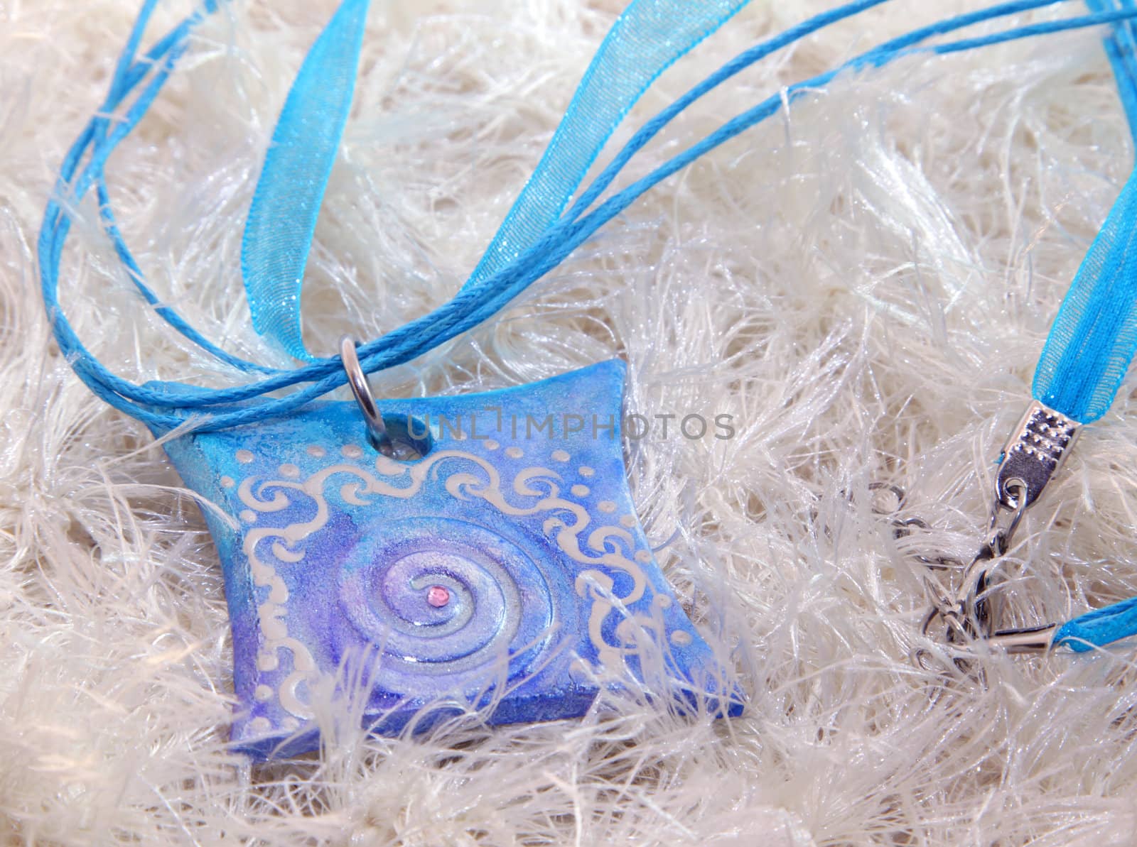 clay handmade blue amulet on a white background