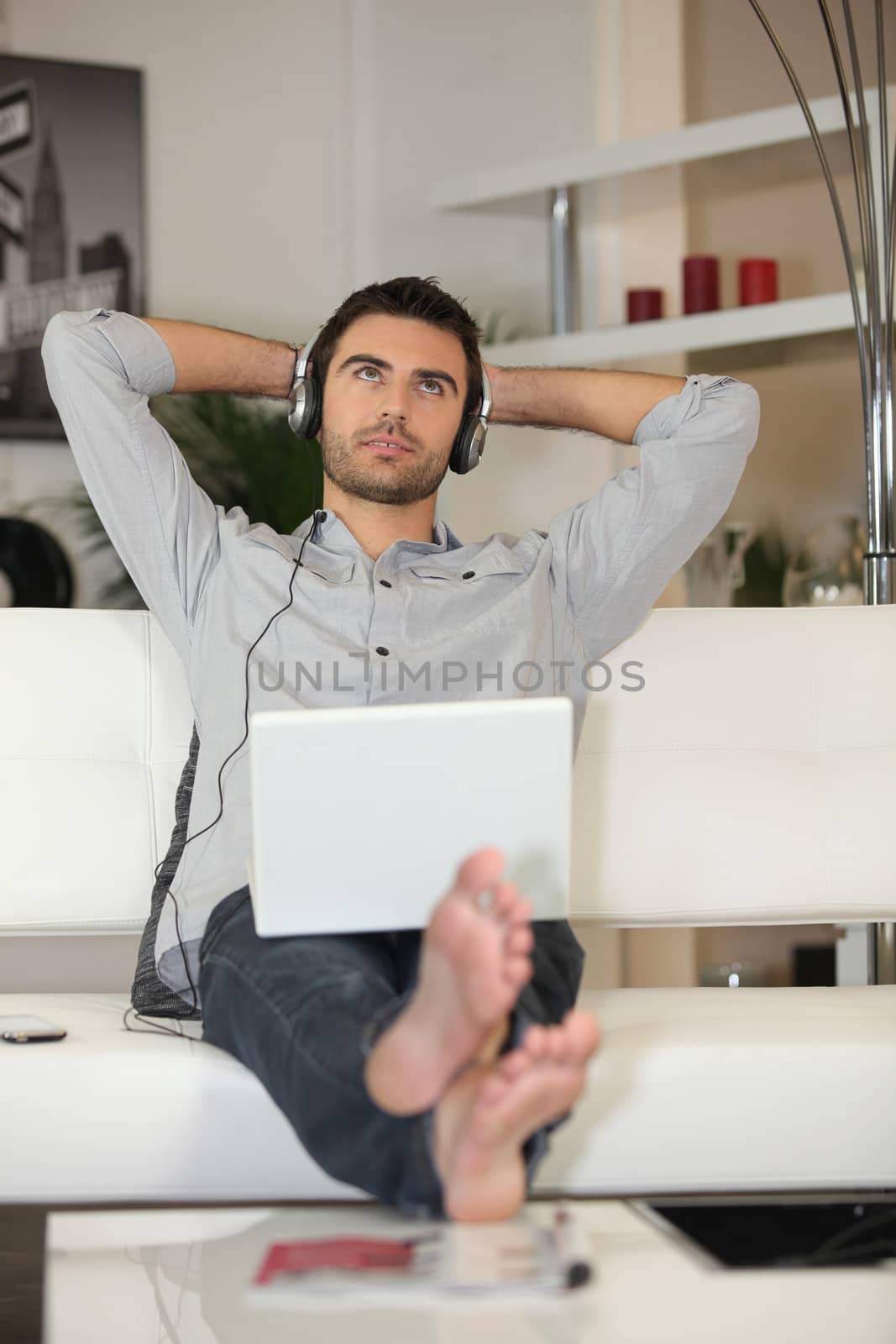 Mans listening to music through laptop