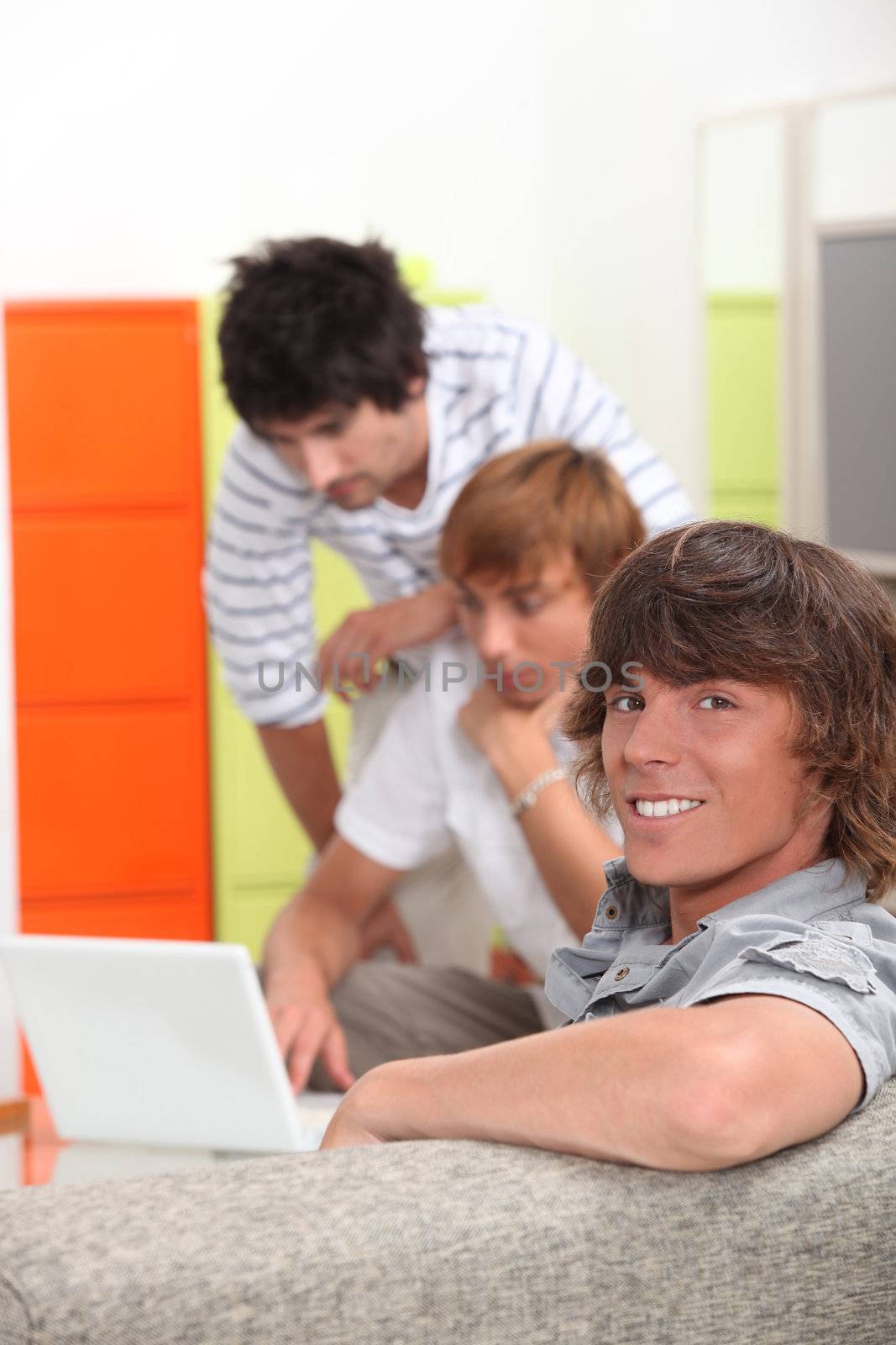 Lads at home with a laptop computer by phovoir