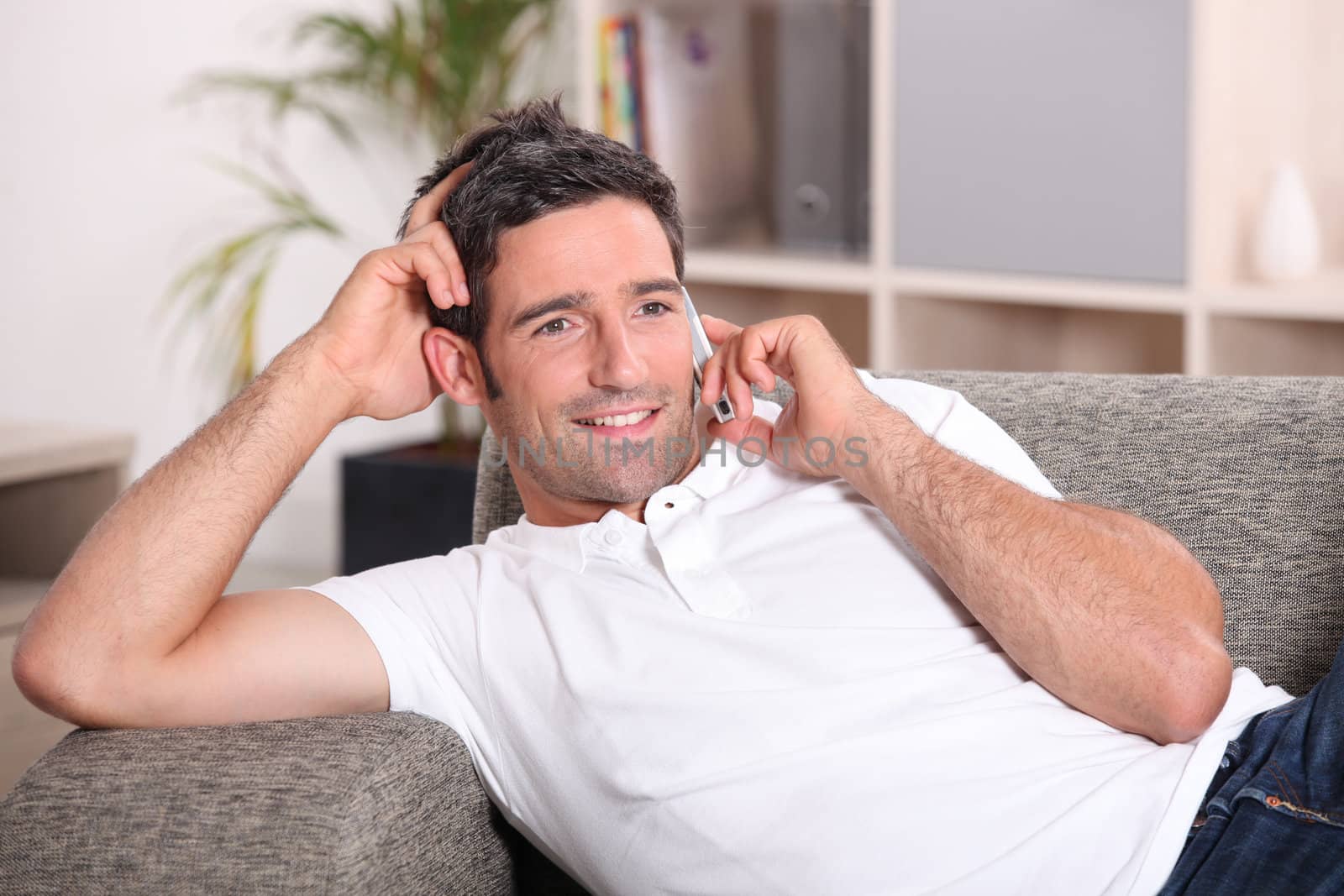 Man with telephone relaxing on sofa