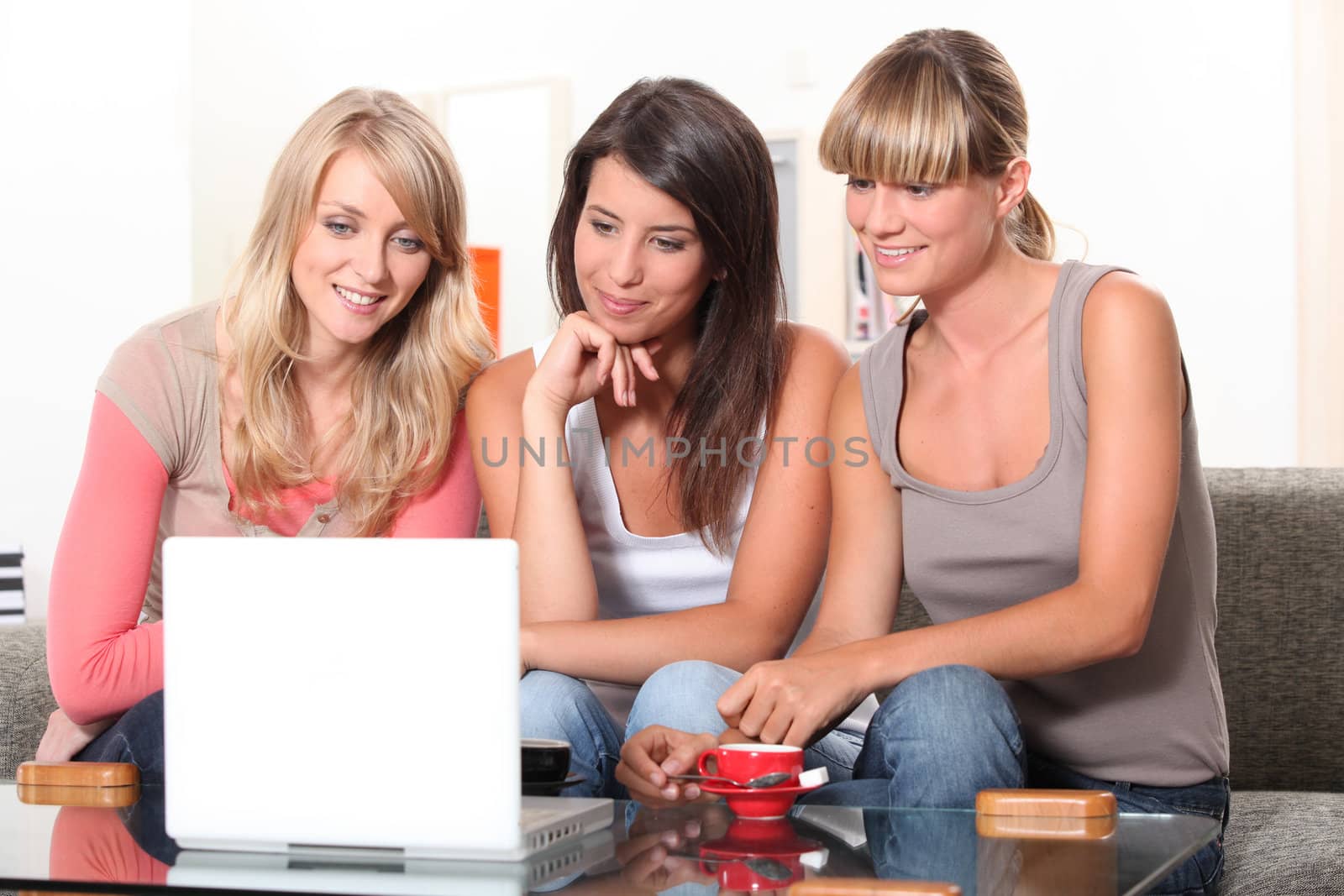 Young women watching a film on a laptop by phovoir