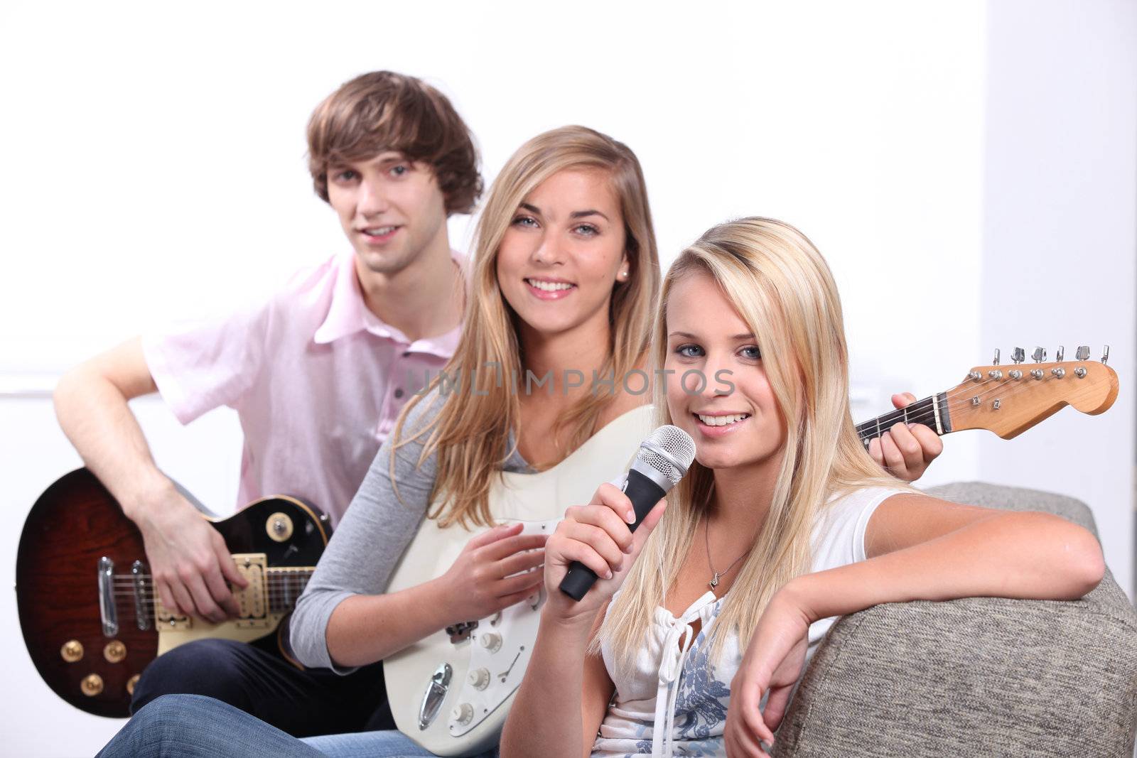 Three teenager playing musical instruments by phovoir
