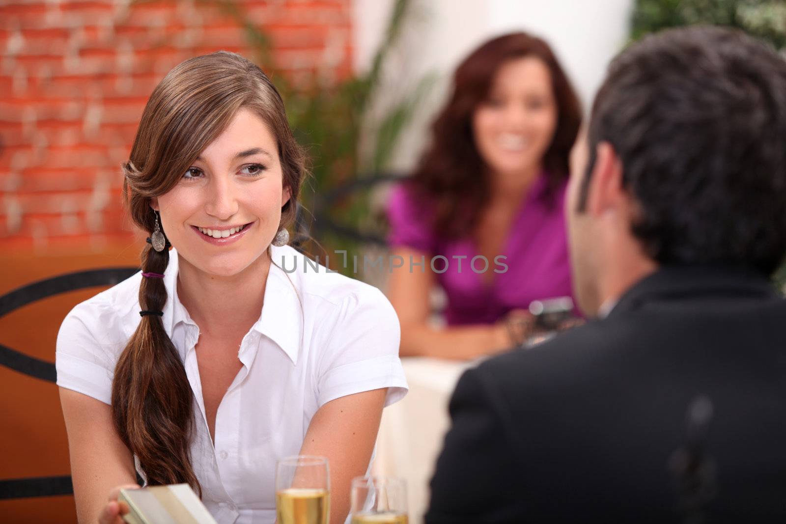 a young woman and a man at the restaurant, sparkling wine flutes on the table