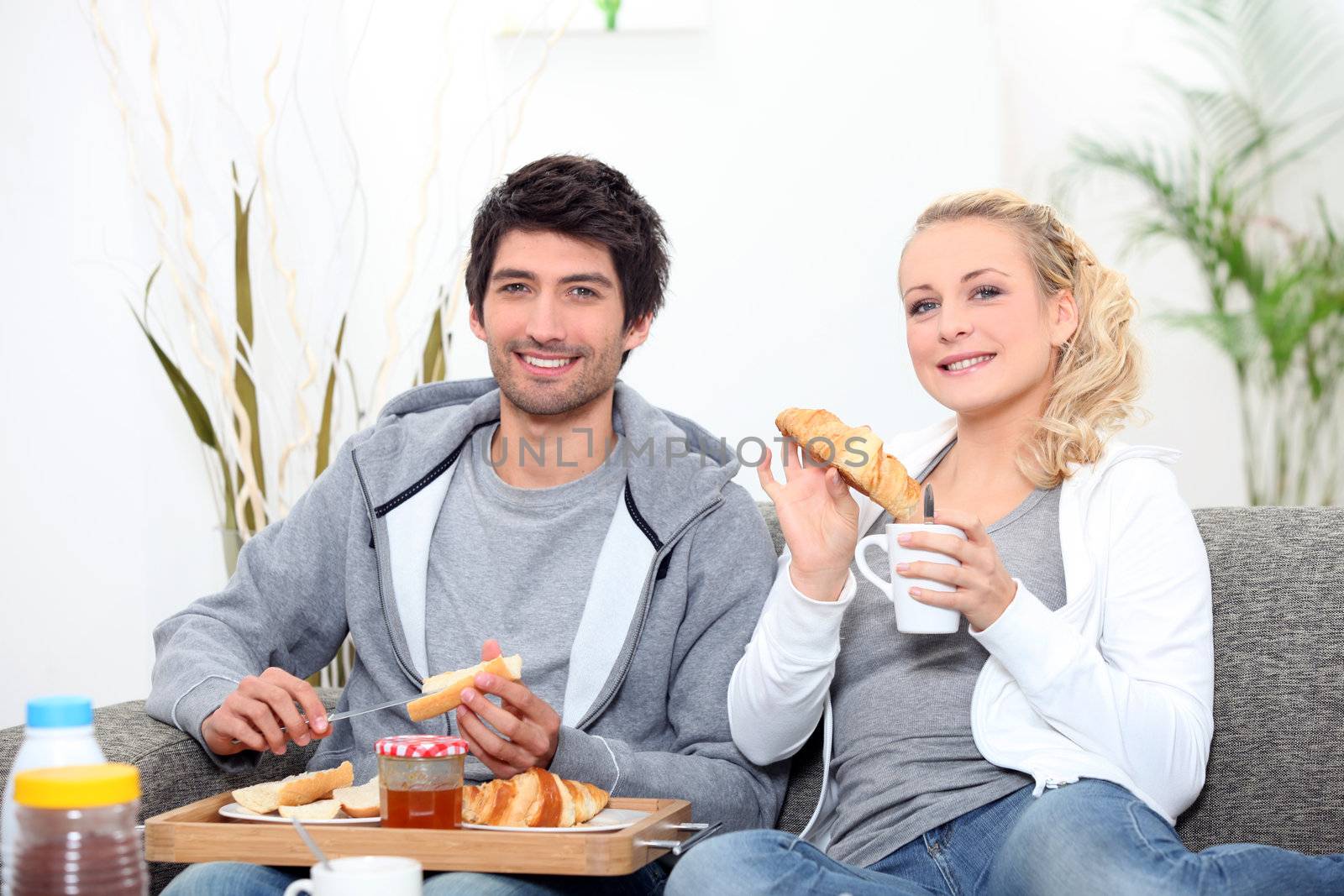 Young couple sharing breakfast in the lounge