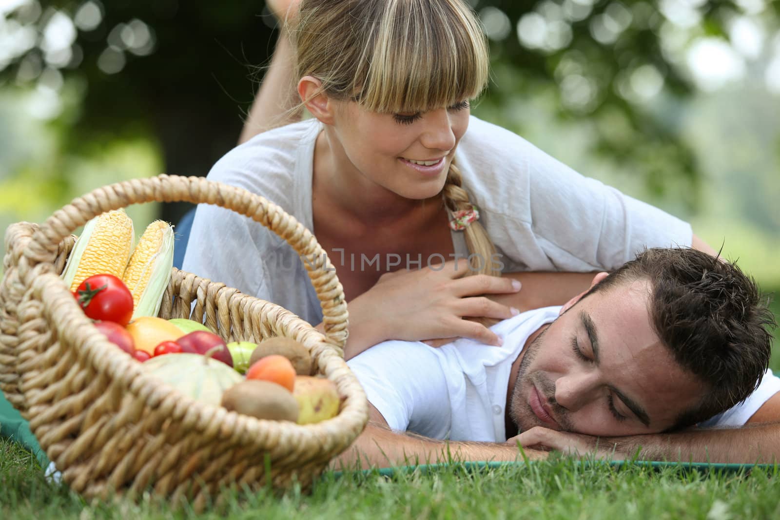 Couple with a basket of produce by phovoir