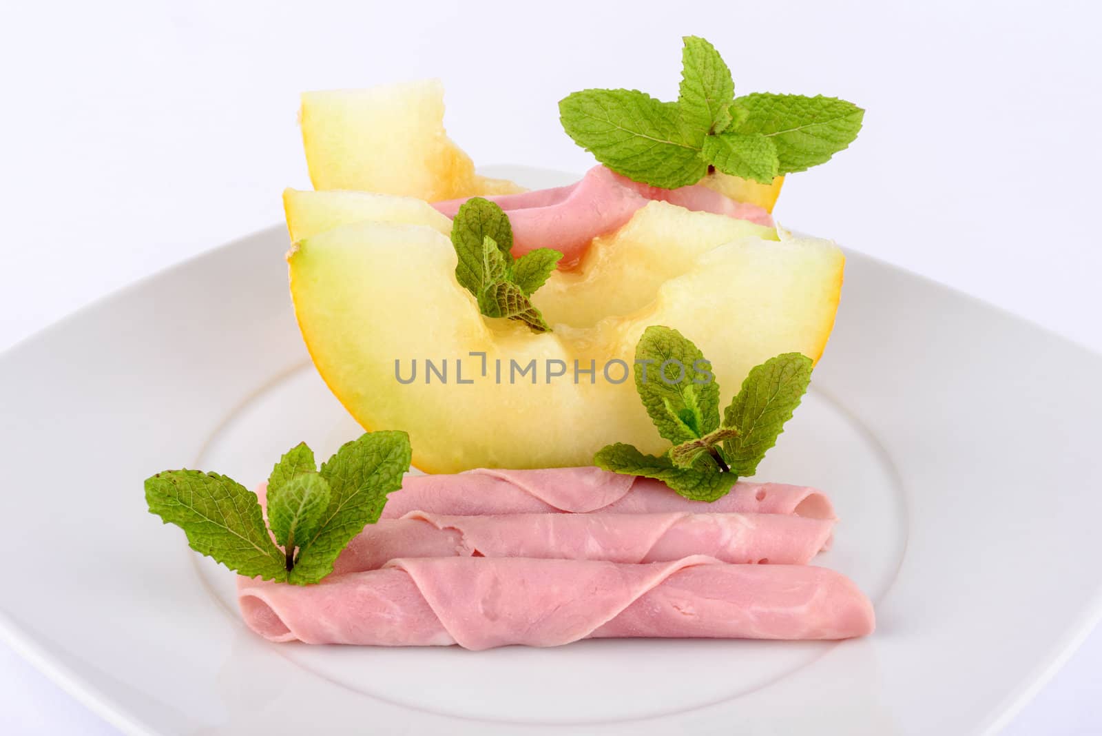 Ham and melon on white background.