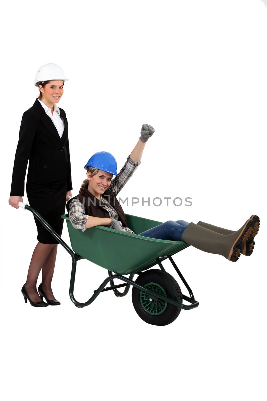 Architect pushing her colleague in wheelbarrow