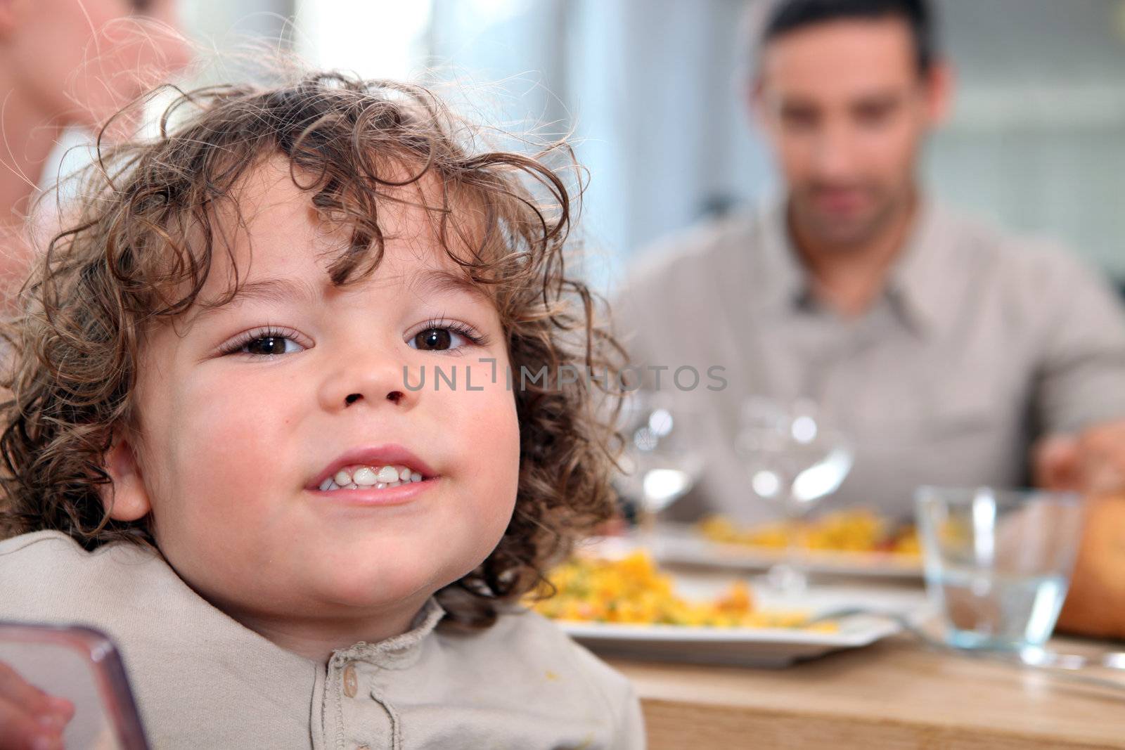 Young girl having a meal with her family by phovoir