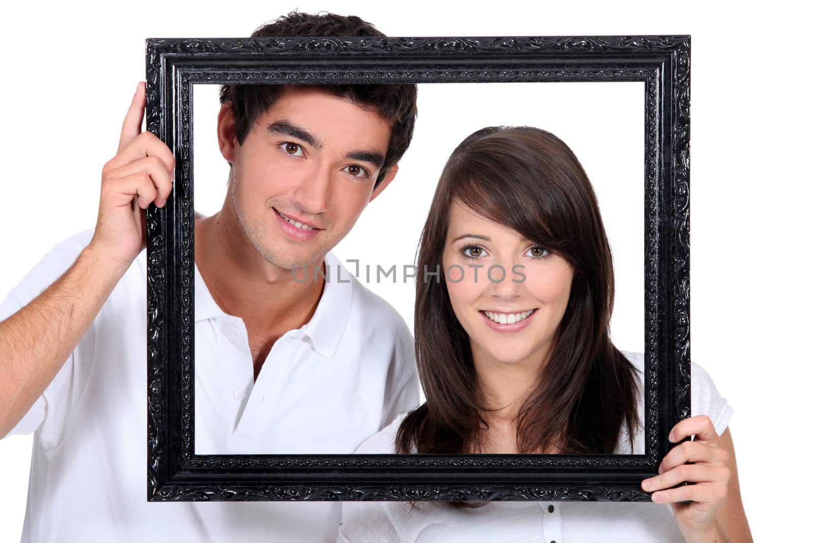 Couple holding empty picture frame by phovoir