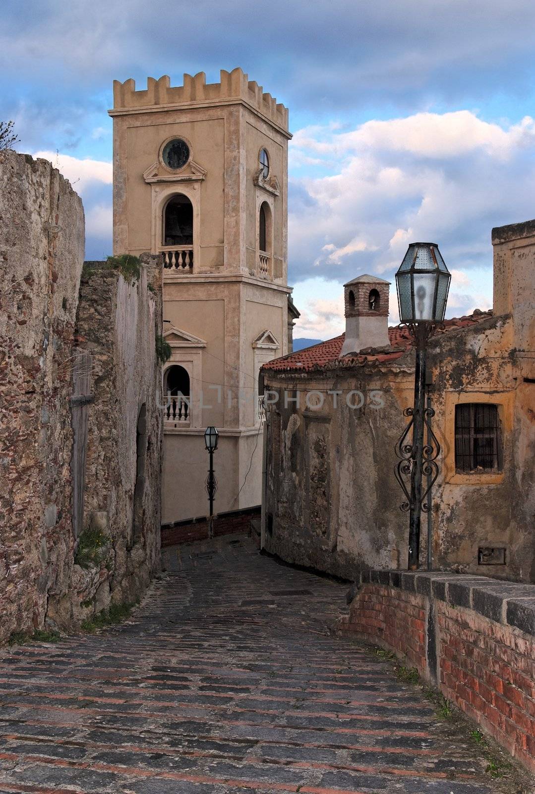 Paved medieval street with church belfry in Savoca village, Sicily, Italy