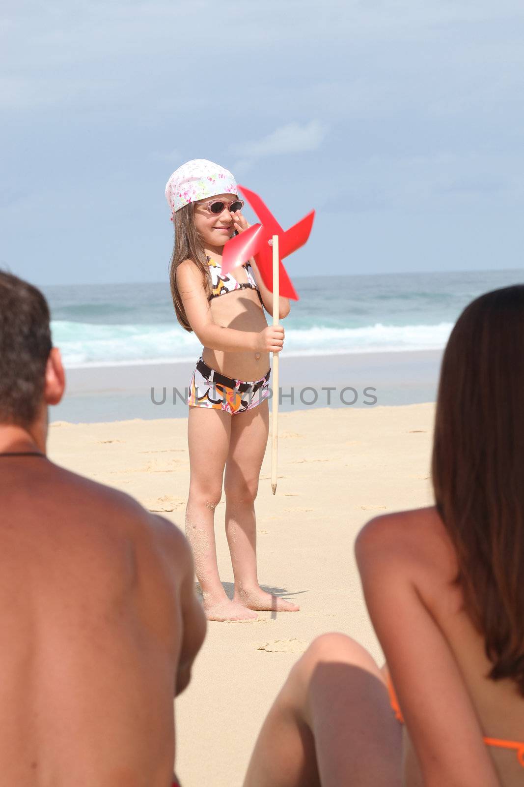 Girl with a windmill on a beach