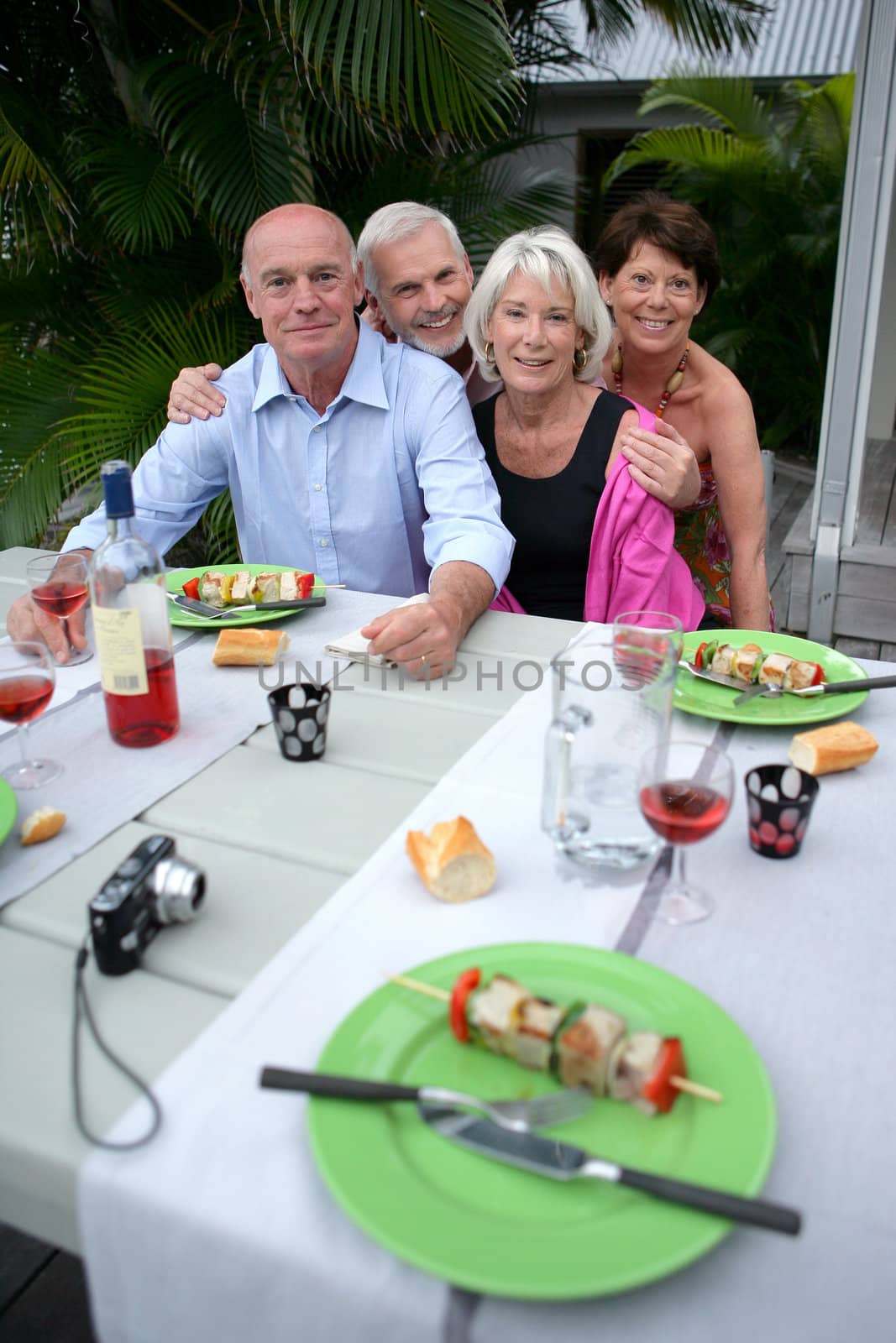 Friends posing for a photo during a barbecue by phovoir