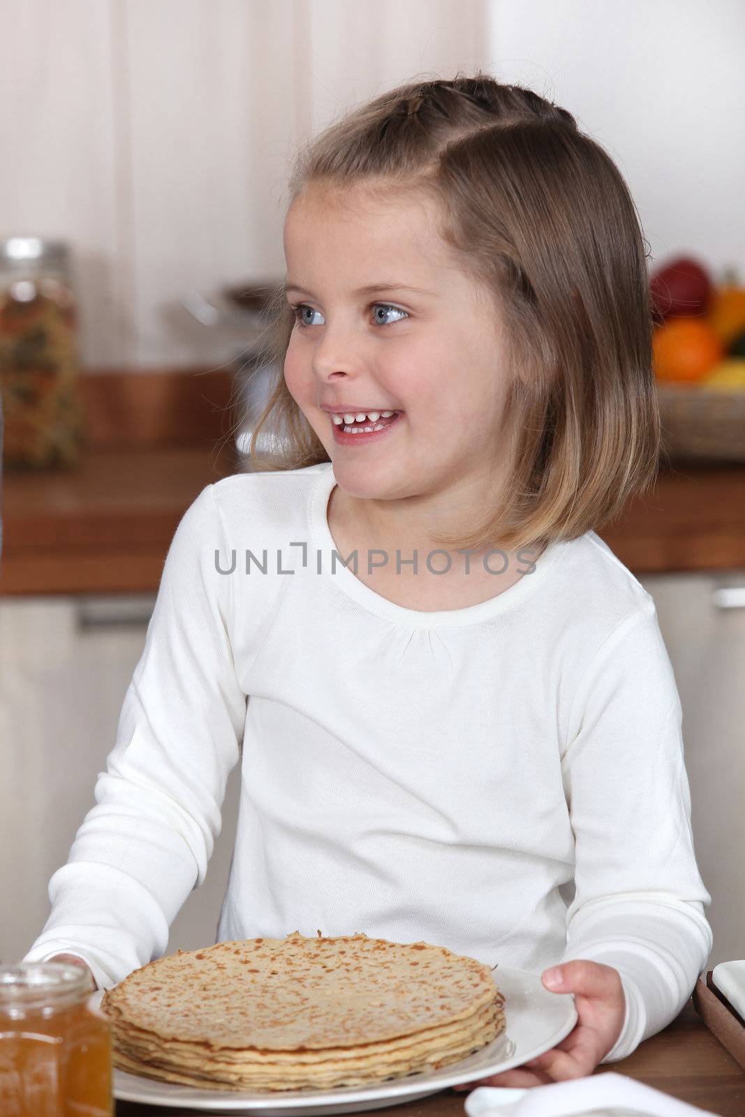 Little girl holding a plate of crepes