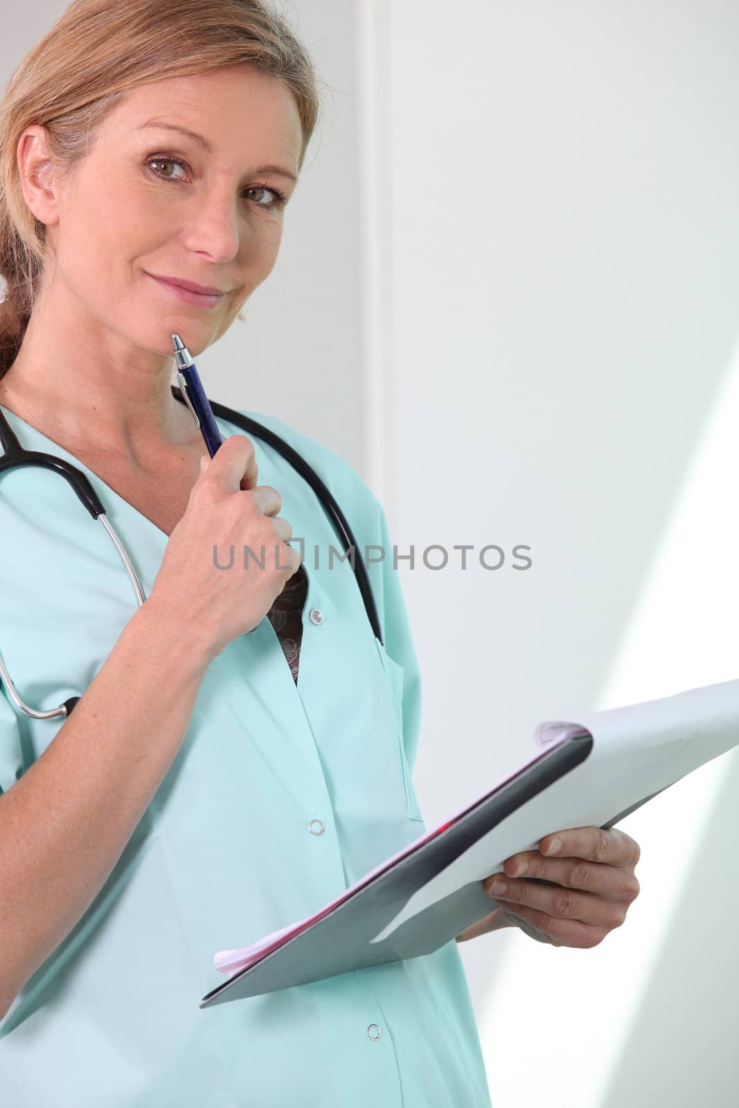 Smiling female nurse looking at notes