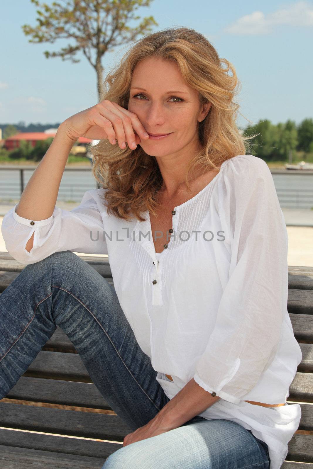 Romantic woman sitting on a bench by phovoir
