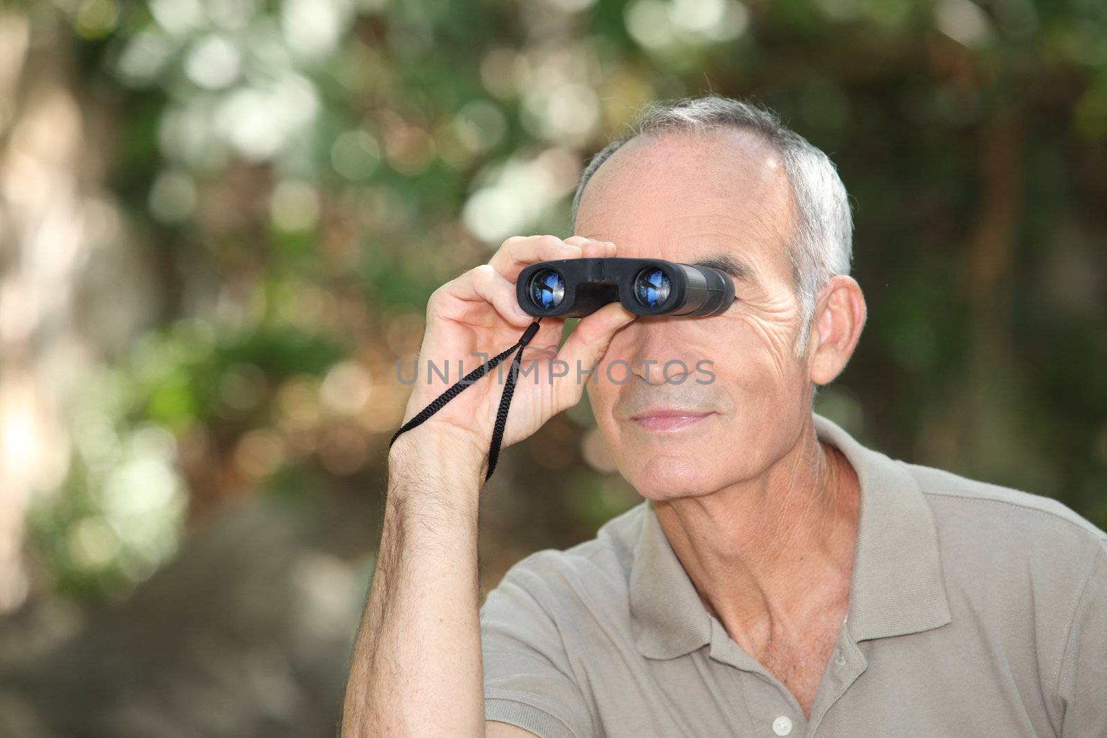 Man using a pair of binoculars by phovoir