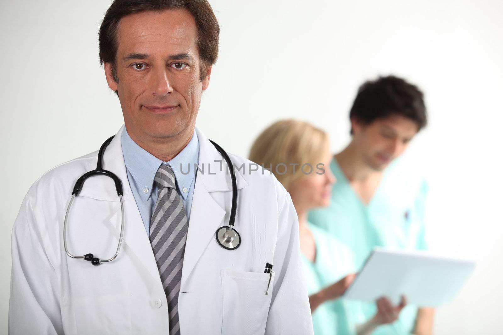 Doctor stood in front of colleagues by phovoir