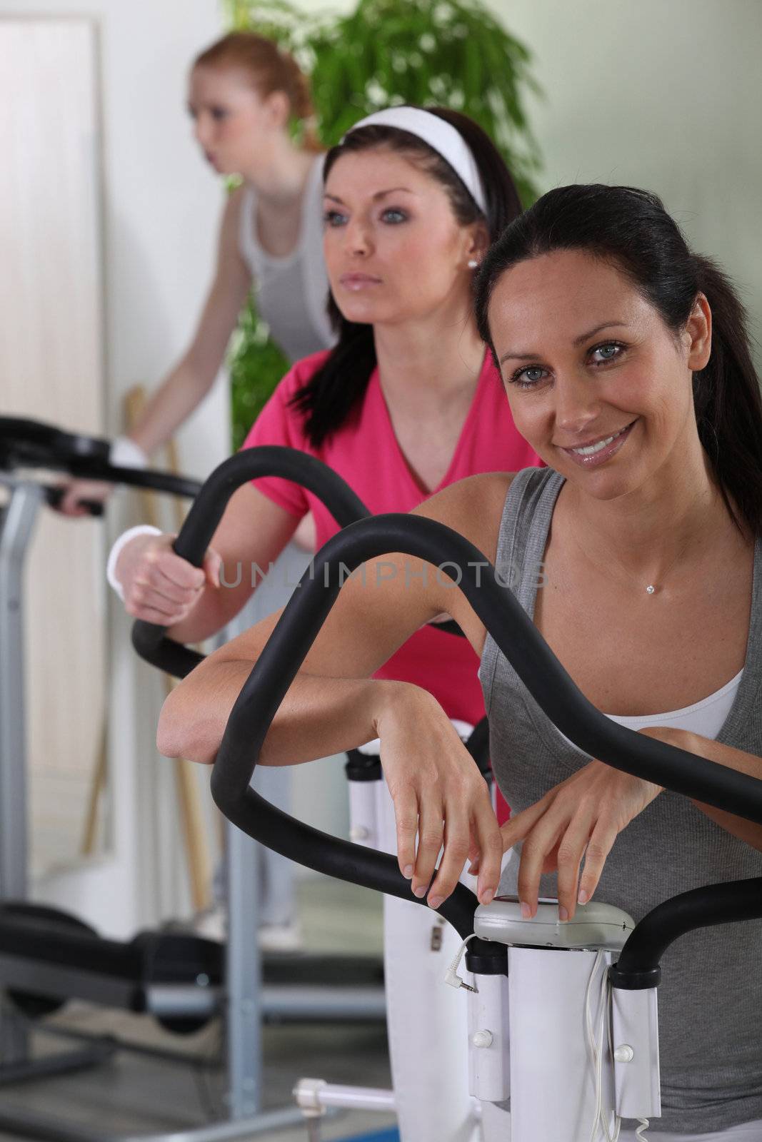Women exercising at the gym by phovoir