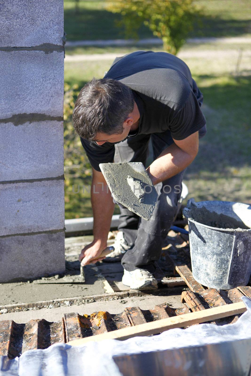 Mason with trowel and cement by phovoir