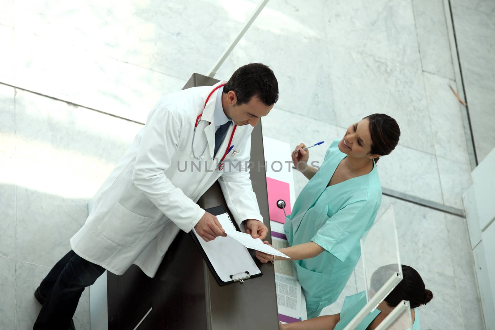 Medical secretary showing record to doctor by phovoir