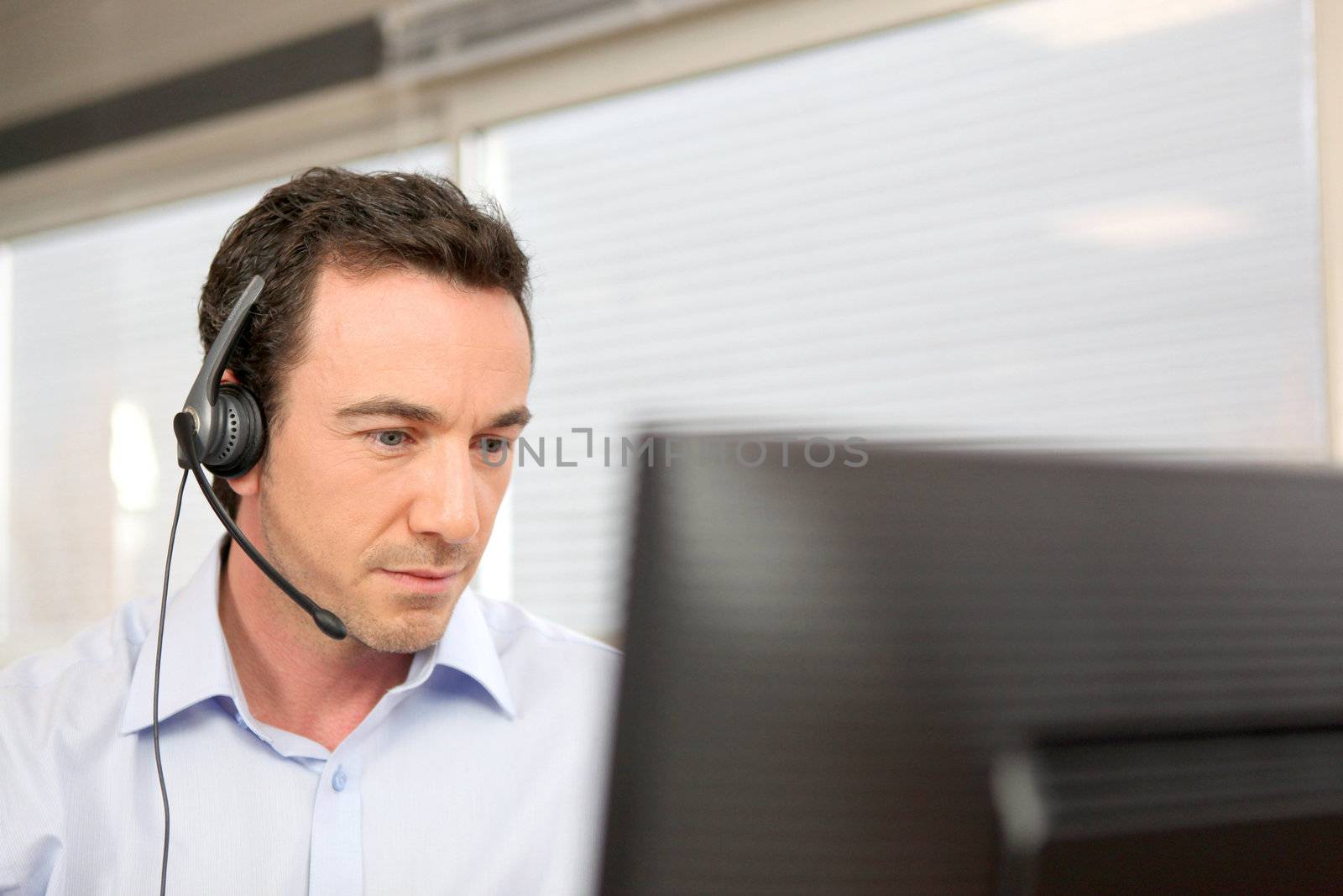 Man using a headset at a computer