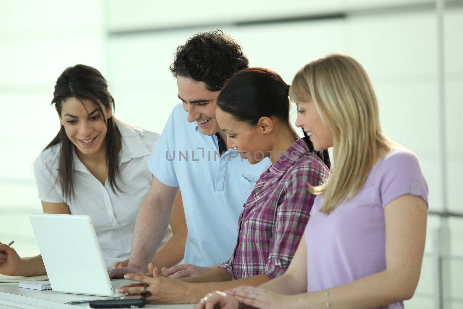 Four colleagues gathered around laptop