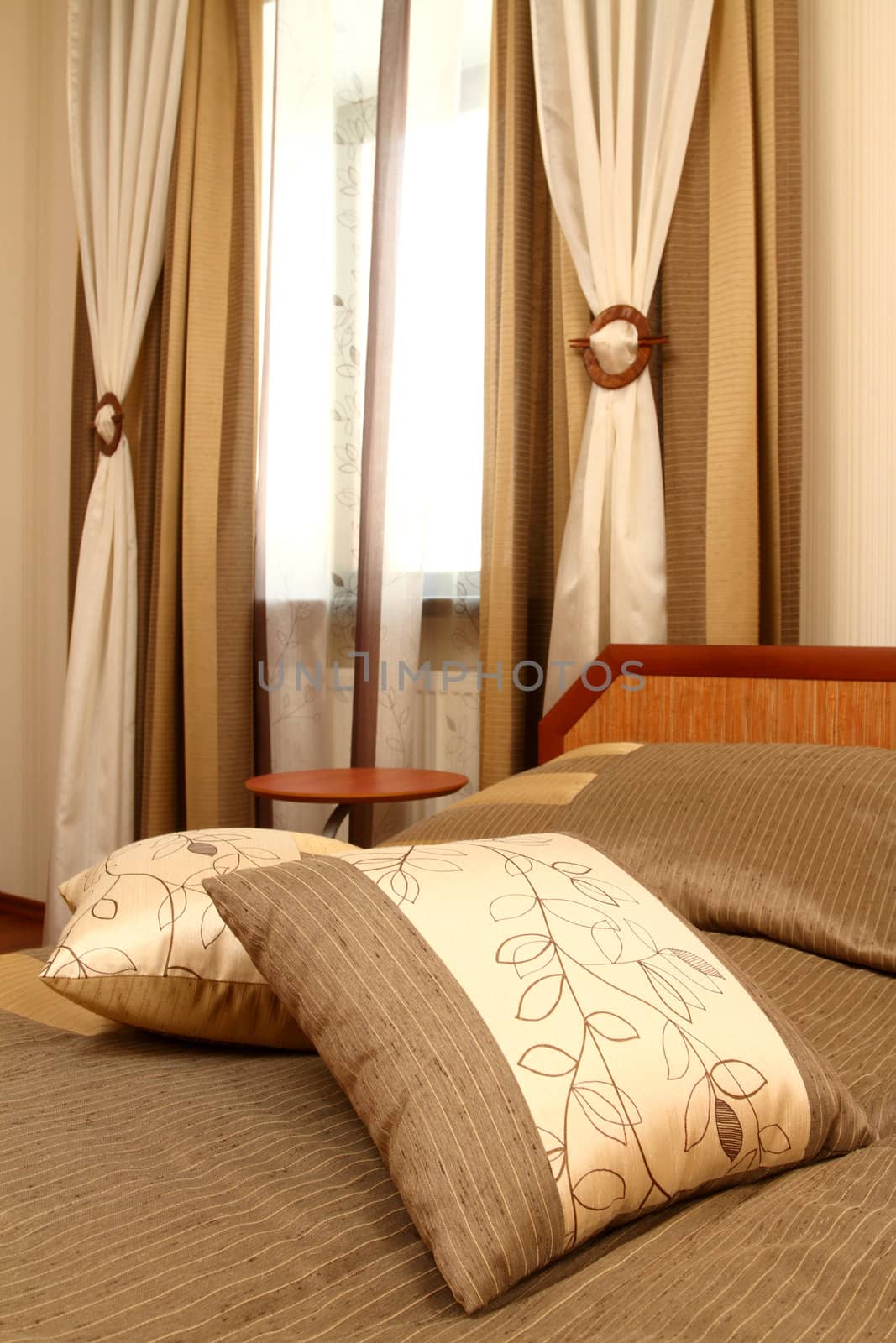 fragment of an interior of a bedroom with a bed and the embroidered pillow