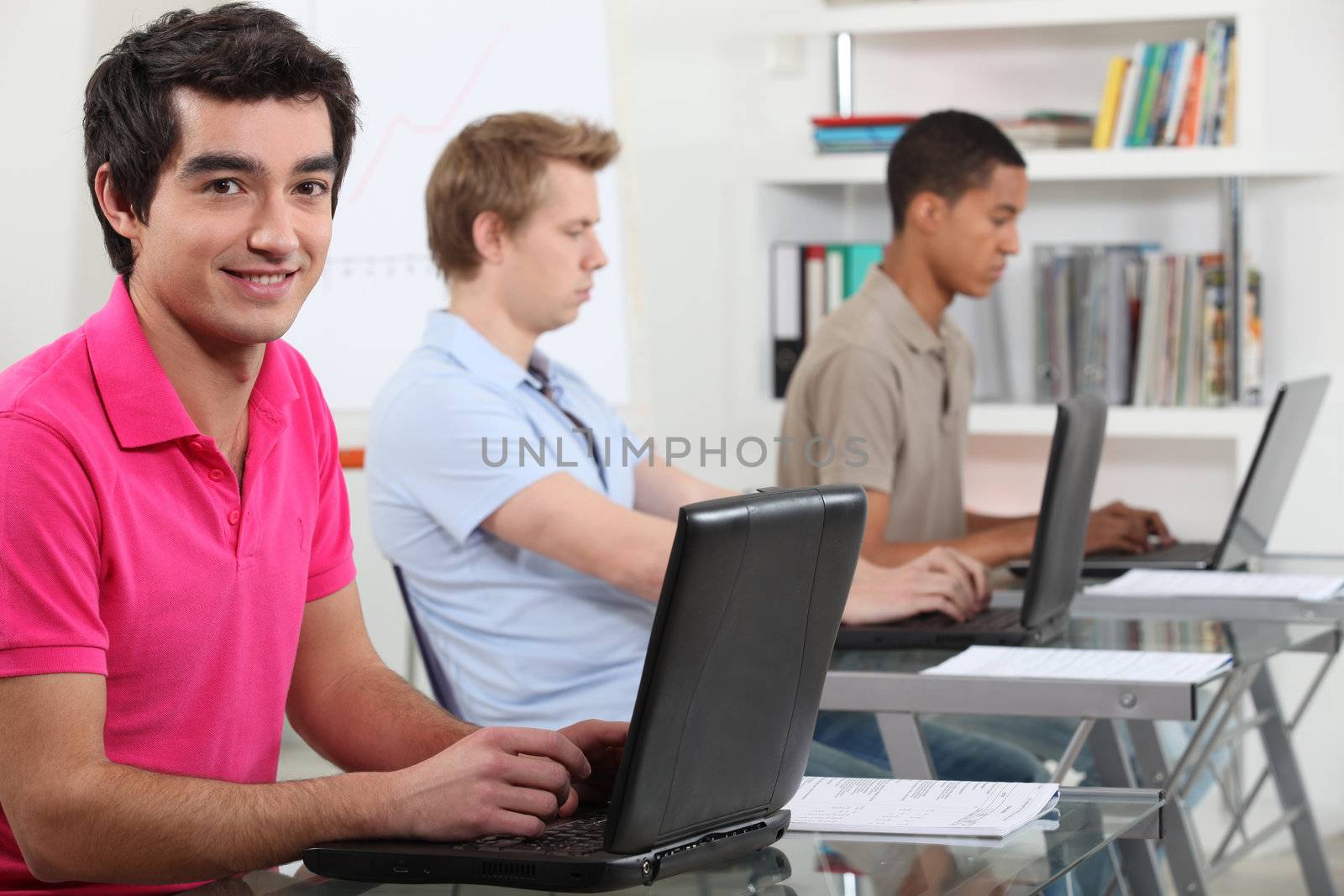 Young men working on their assignments in a computer lab