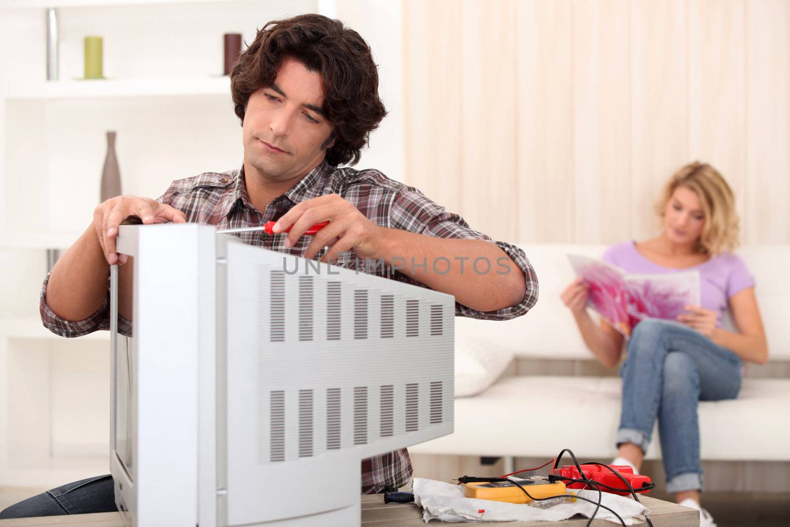 technician repairing a television by phovoir