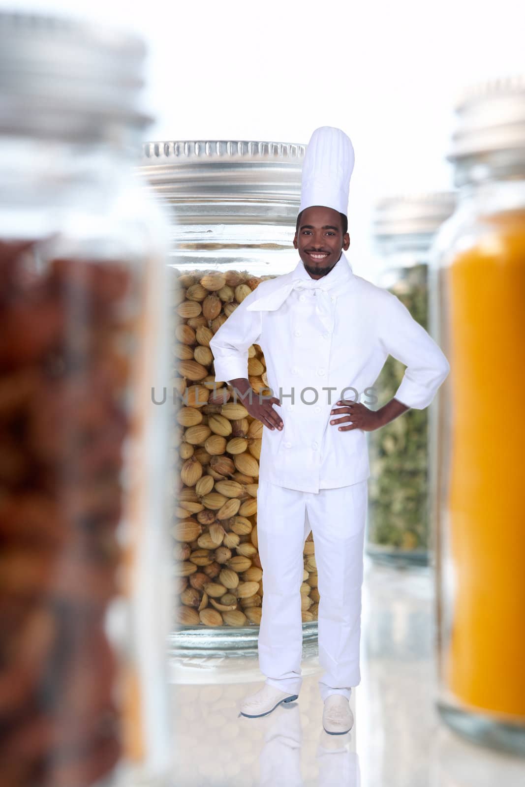 black cook amid giant jars filled with food goods