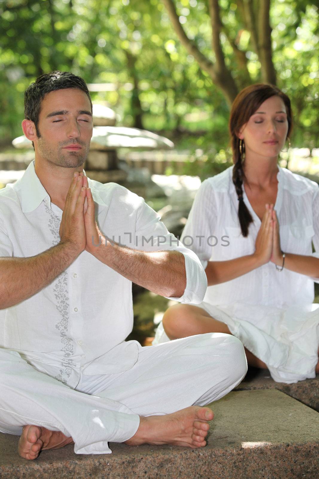 Couple meditating in stone garden
