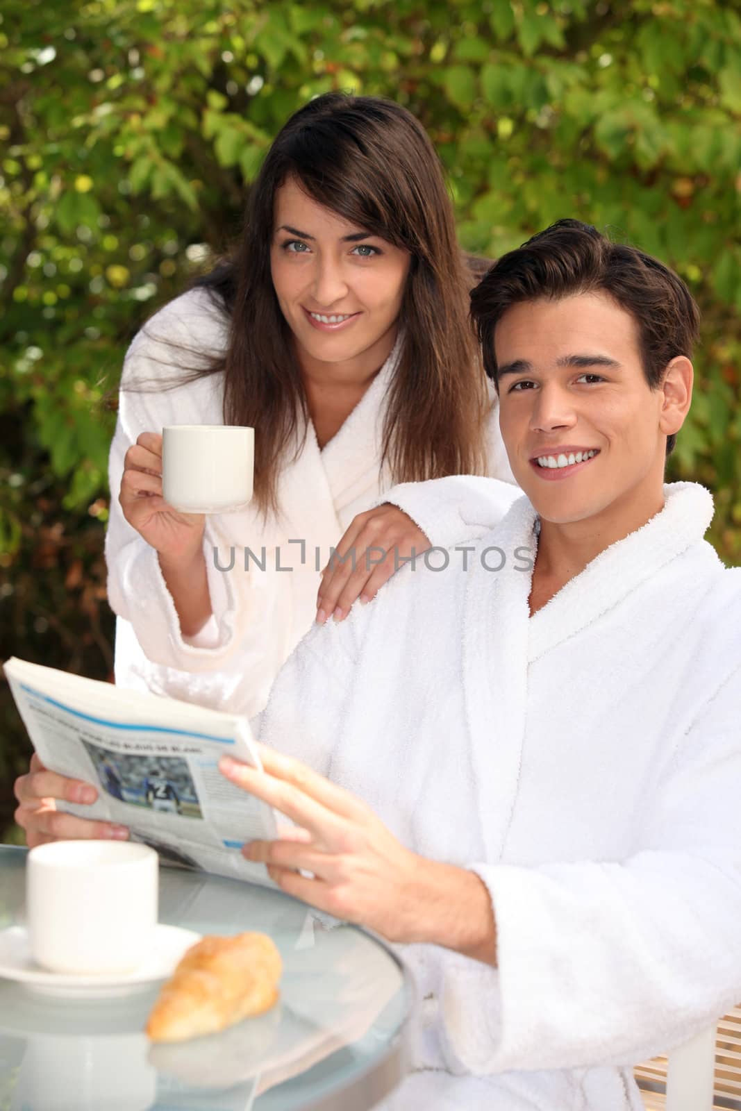 young couple on vacation having breakfast by phovoir