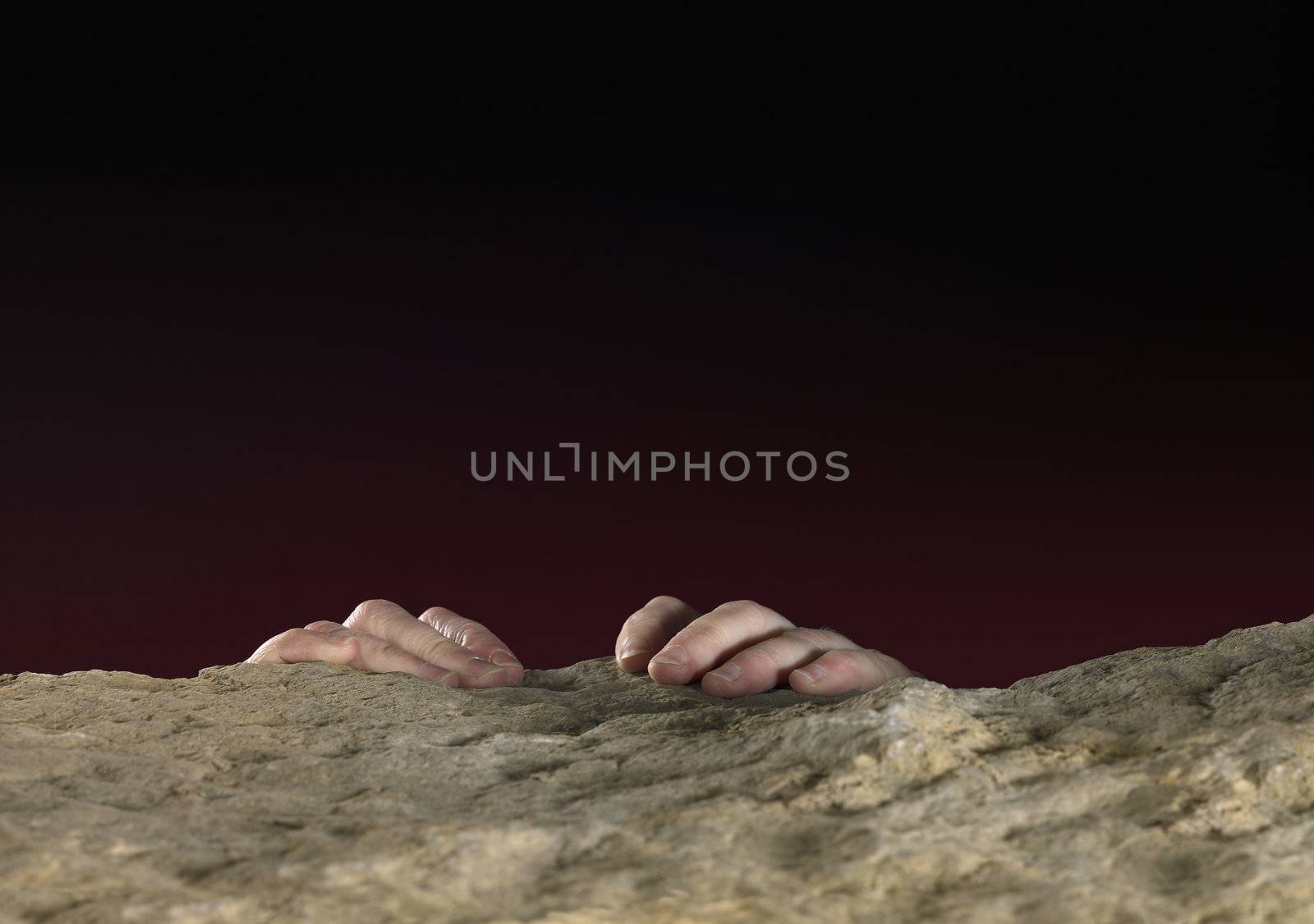 hands clutching on stone surface in dark back