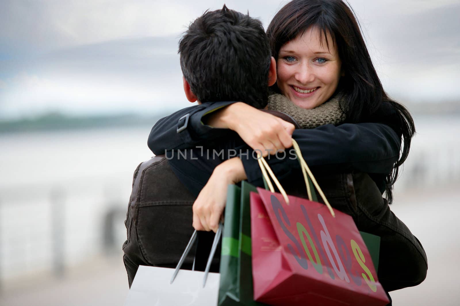 Couple with shopping bags hugging by phovoir
