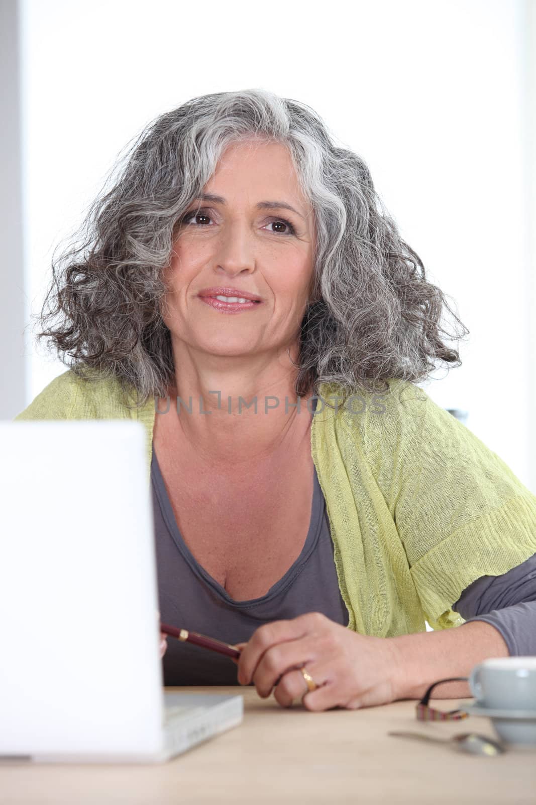 Gray-haired woman in front of laptop computer