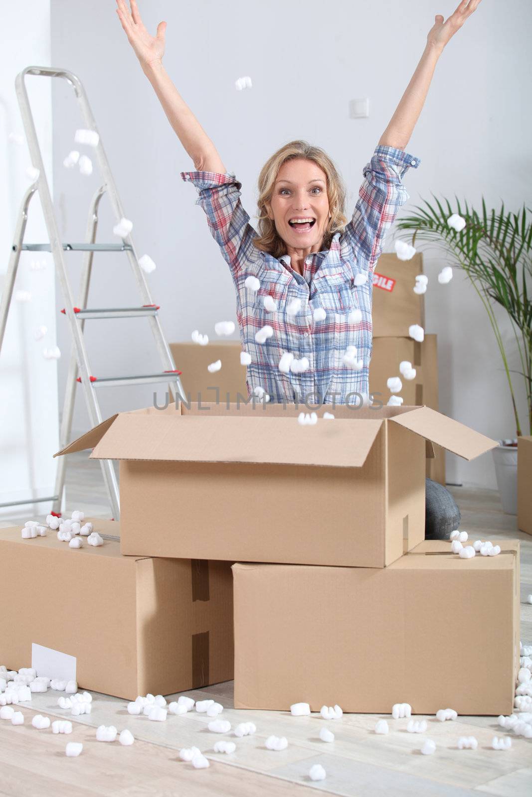 Woman crouching in front of stacked cardboard boxes