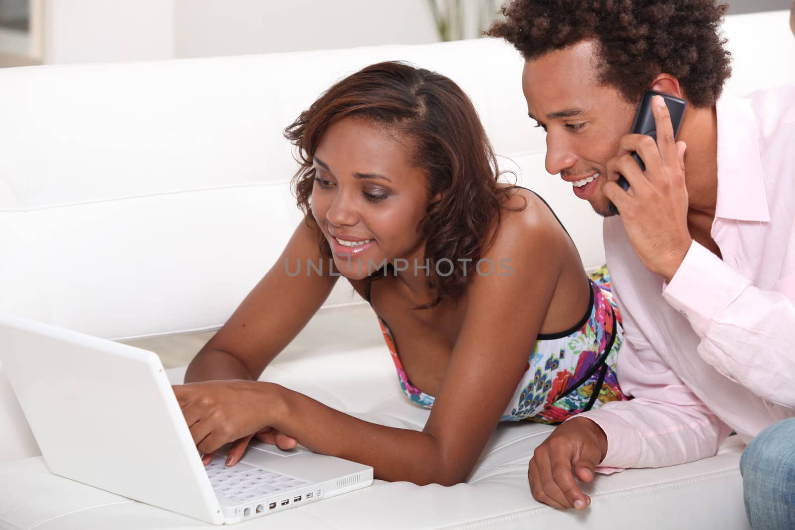 Couple looking at a laptop on a sofa