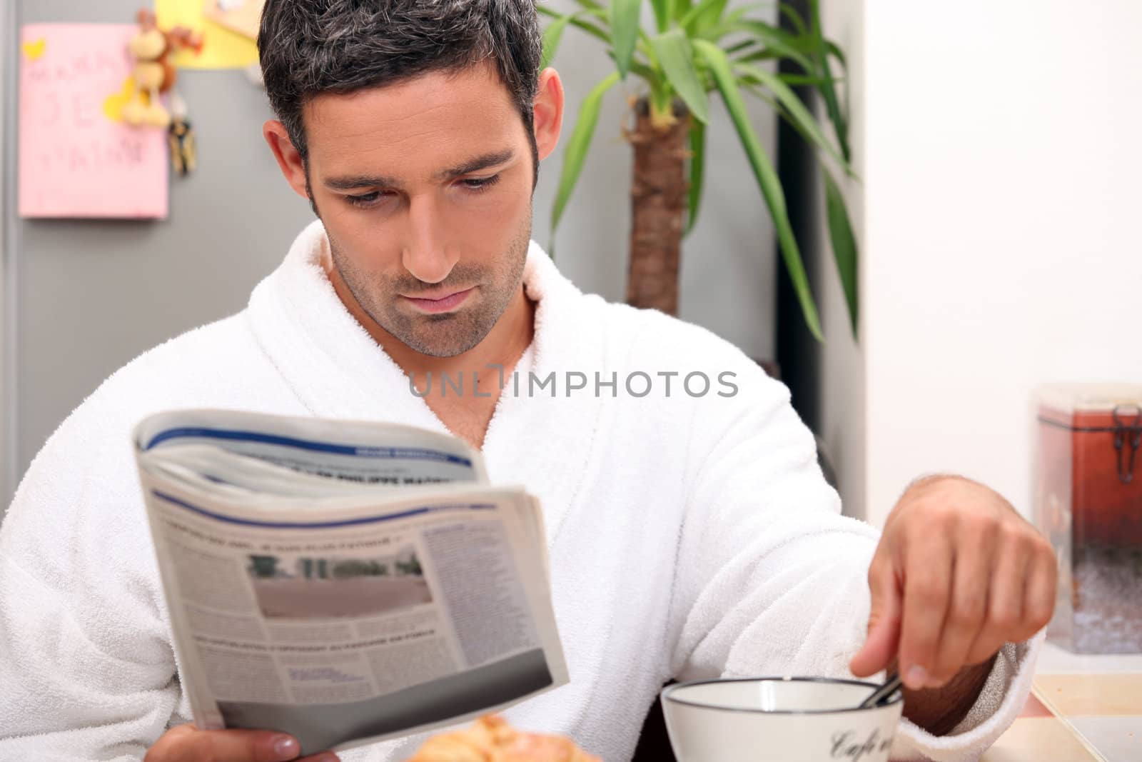 Man having a leisurely breakfast while reading the paper