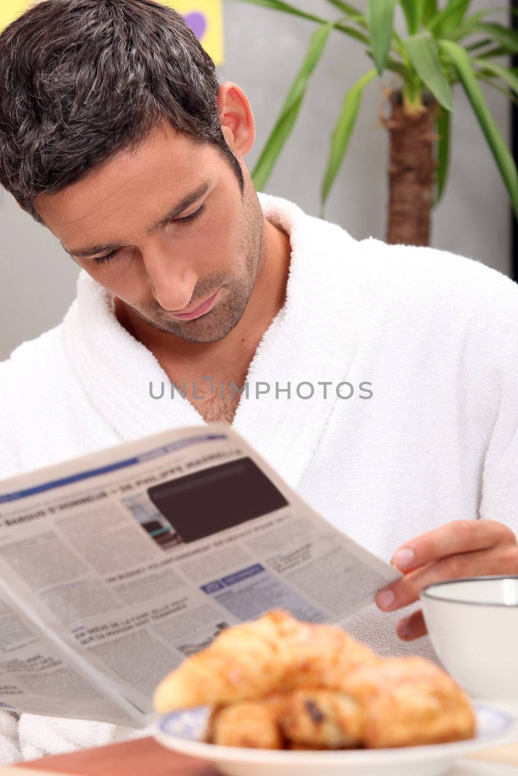Man reading a journal over breakfast