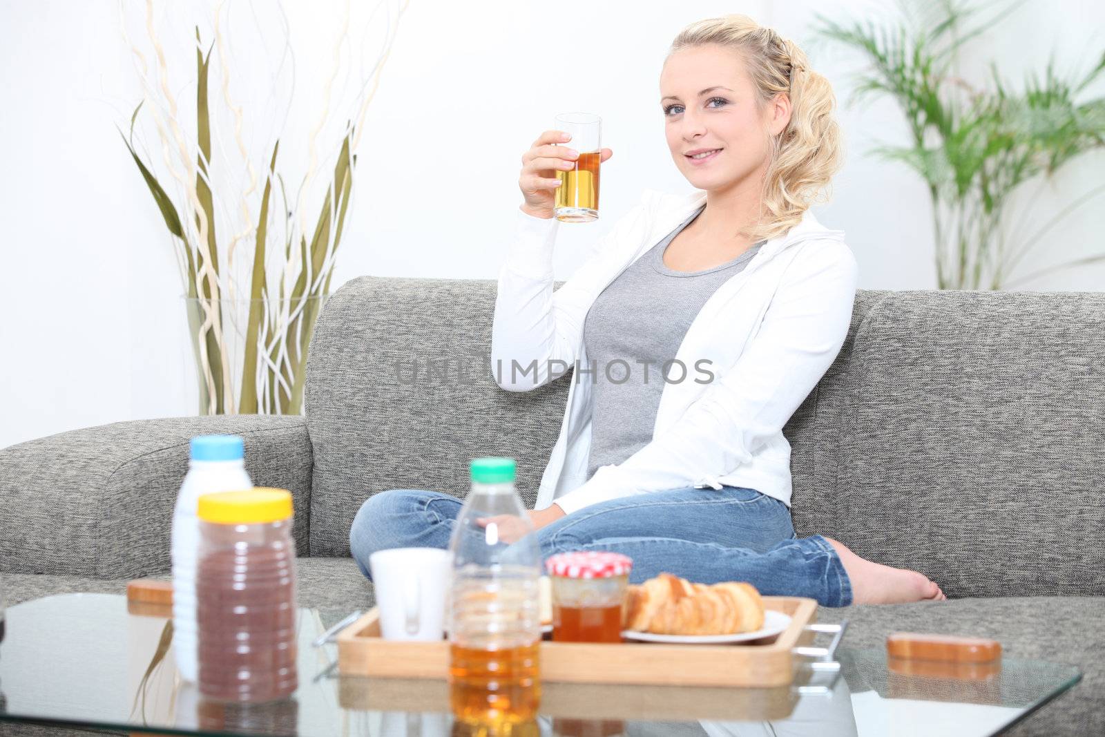 Woman having breakfast in her living room